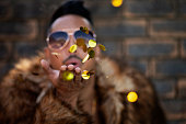 Face, fashion and blow a kiss with man on wall background for love, romance or affection closeup. Portrait, hand and glitter with young model in sunglasses flirting with emoji gesture or expression