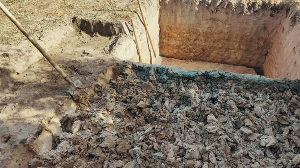 istock Pit in the ground. Digging a pit. The shovels in the pit. Earthworks, digging trench. 1960145903