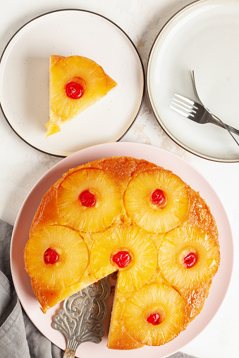 Homemade pineapple upside down pie with candied cherries . Tropical dessert on white background. Top view