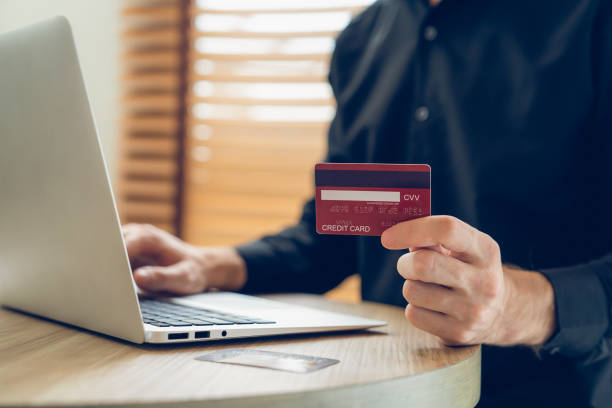 istock Young man using laptop with credit card for internet banking. Unveiling 1960164888