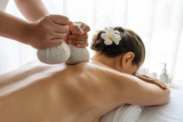 hot herbal ball spa massage body treatment at day spa . quiescent - massaging thailand thai culture shiatsu 뉴스 사진 이미지