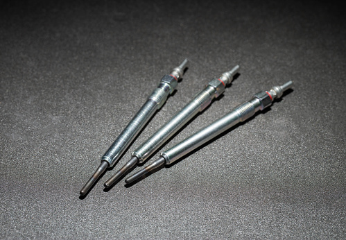 Modern rod ceramic glow plugs for easier starting of a diesel engine in cold weather on a gray background. Automotive spare part, heating element, engine preheater