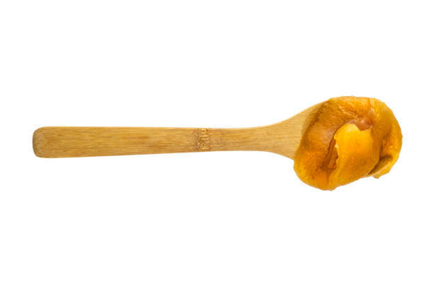 Fresh honey in a wooden spoon isolated on white background, flat lay, table top view