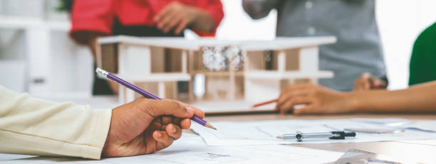 istock Professional architect team discussing about house design. Closeup. Variegated. 1960229037