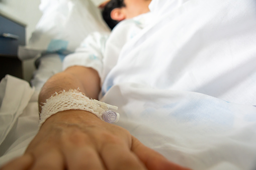 Medical Care in Focus: Patient in Hospital Bed with IV Drip.