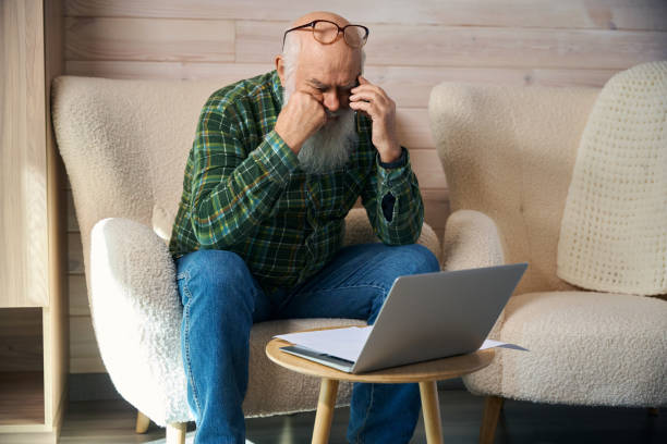 istock Old man is tired, working with documents in living room 1960258947