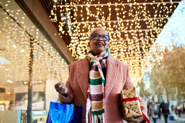 Smiling Christmas shopper carrying bag and gift