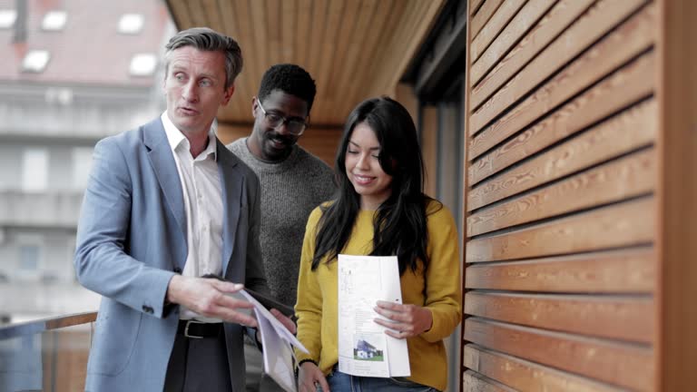 Real estate agent presenting new home to interracial couple