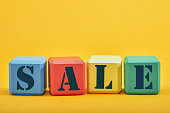 different colored blocks with the wordings SALE, isolated against yellow background.