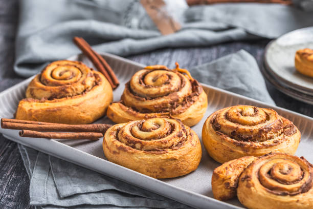istock Homemade cinnamon rolls on a gray earthenware tray on gray background 1960315518