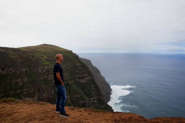 istock Man looking at Ponta do Pargo lighthouse 1960317122
