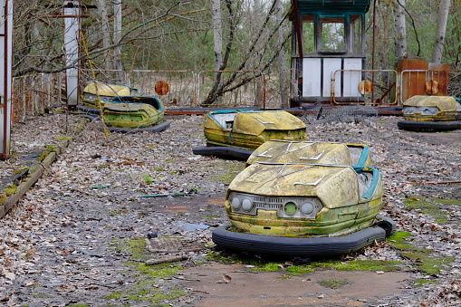 Cars in an abandoned amusement park in Pripyat. Rusty deserted attractions.