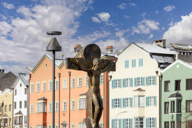 Statue of Jesus crucified on the cross, Crucifix by Rudi Wach on Inn Bridge, Innsbruck, Austria Innsbruck, Austria - February 26, 2023: Statue of Jesus crucified on the cross, Crucifix by Rudi Wach on Inn Bridge. Colourful Houses Innsbruck in a background what mountain was jesus crucified on stock pictures, royalty-free photos & images