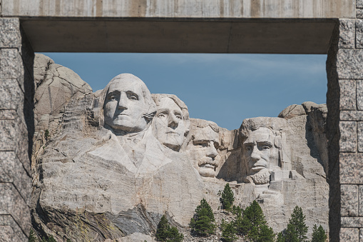 An archway framing Mt. Rushmore, featuring the faces of four famous U.S. Presidents carved into the mountainside.