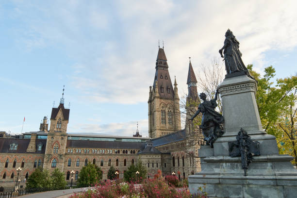 Ottawa,Canada,October 8,2023-Visitors take in the views of the Gothic revival style Parliament buildings and the Wilifrid Laurier statue, Canada's heritage monuments