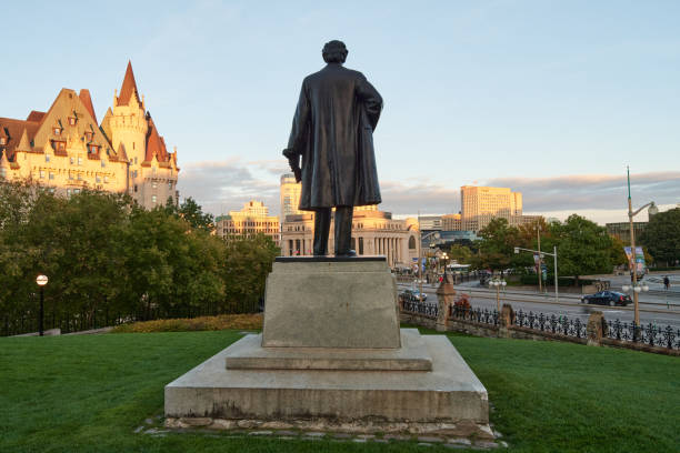 Statue of Wilfrid Laurier Ottawa, Ontario, Canada; 16th of October, 2023. Back view of the Wilfrid Laurier statue, former minister of Canada,  the Senate of Canada and Fairmont Chateau Laurier hotel in the sunset wilfrid laurier stock pictures, royalty-free photos & images