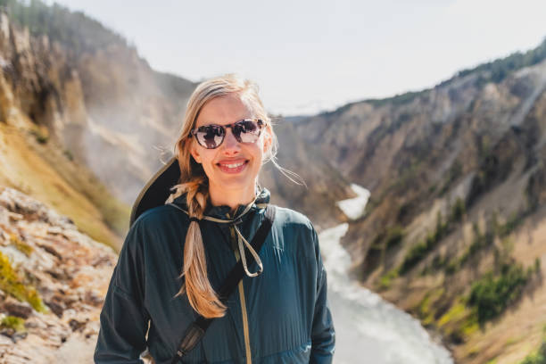 jeune femme souriante au sommet du grand canyon de la rivière yellowstone, dans le parc national de yellowstone - eroded water grand canyon of yellowstone river river photos et images de collection