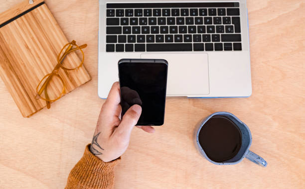 istock man using smartphone and laptop with cup of coffee. Close-up. 1960398970