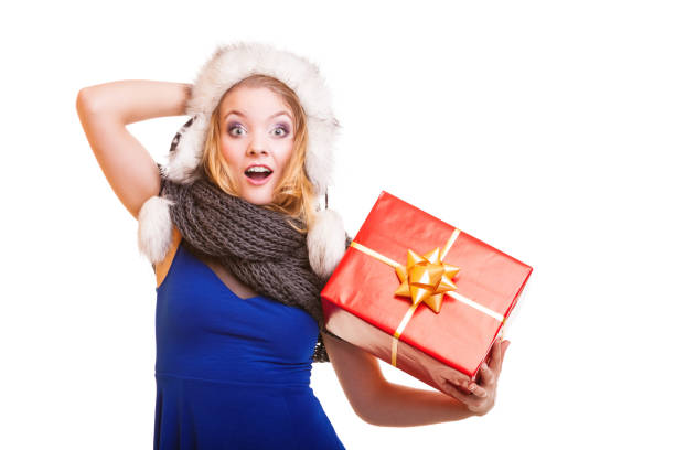 Christmas holidays valentine's day, celebration and happy people concept - blonde girl in winter fur hat with red gift box present isolated