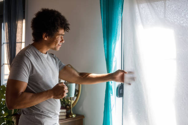 istock Man looking out the window while enjoying his morning coffee 1960404827