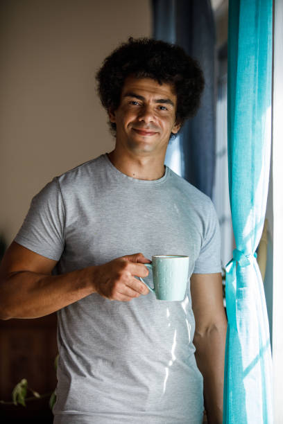 istock Man enjoying his morning coffee by the window 1960404844