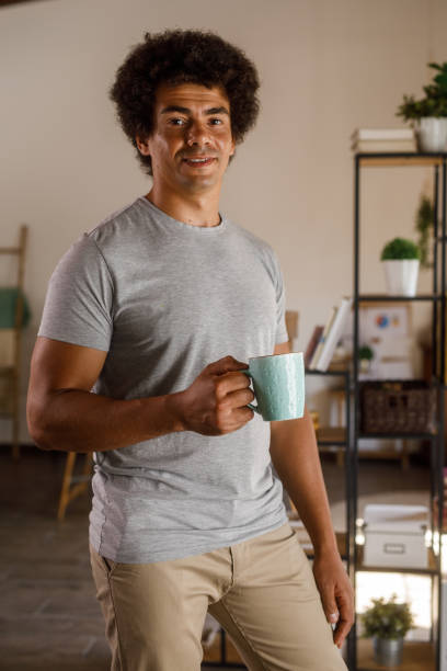 istock Man walking around his home, carrying a cup of coffee 1960405876