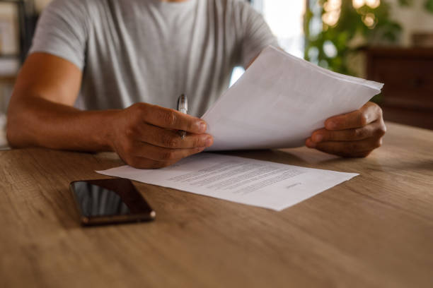istock Man sitting at table, reviewing documents and signing contracts 1960406921