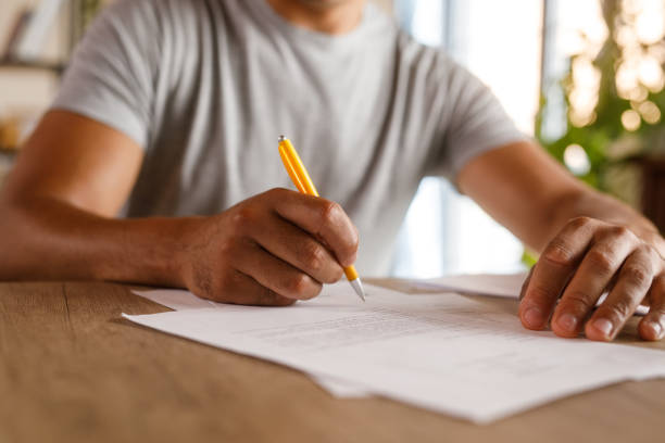 istock Man sitting at table, reviewing documents and signing contracts 1960406923