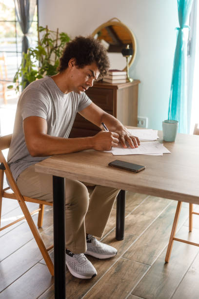 istock Man sitting at table, reviewing documents and signing contracts 1960406924