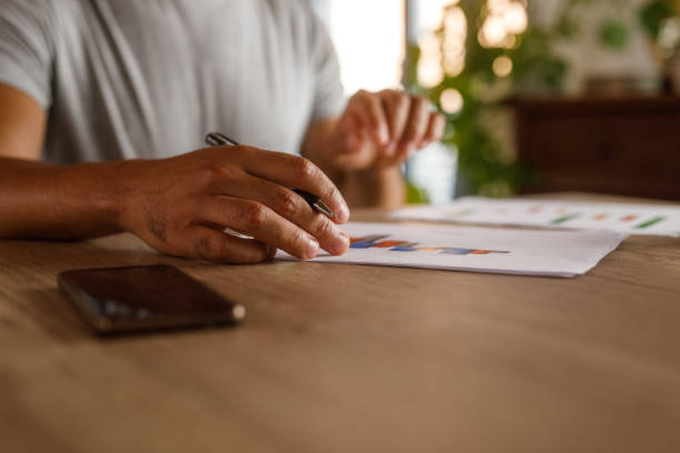 istock Man sitting at table, reviewing documents and signing contracts 1960406926