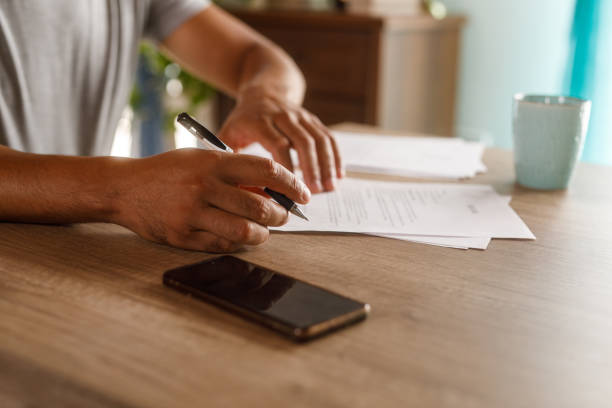 istock Man sitting at table, reviewing documents and signing contracts 1960406927