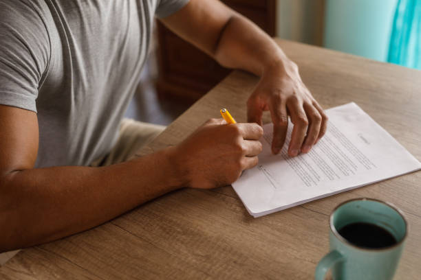 istock Man sitting at table, reviewing documents and signing contracts 1960406932