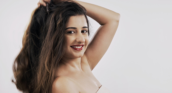 Hair, portrait and Indian woman happy in studio with volume, shine and shampoo, treatment on white background. Haircare, beauty and face of female model with volume, texture or growth satisfaction