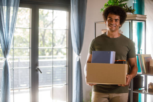 istock Man holding a box with his belongings when moving into new home 1960419580