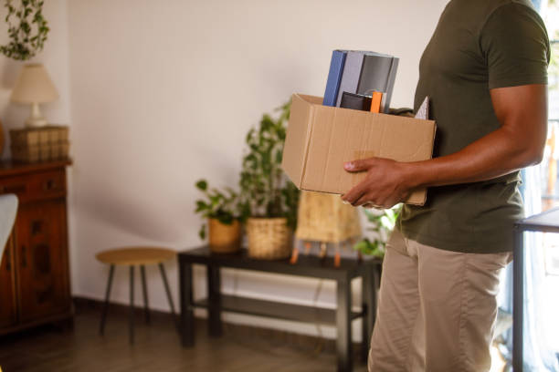 istock Man holding a box with his belongings when moving into new home 1960419588