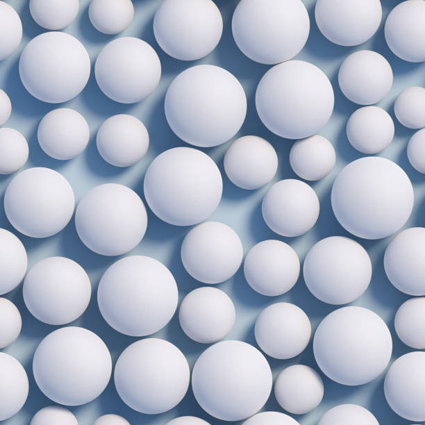 istock White Spheres in different sizes with a rough surface on a blue plane. Seamlessly tileable image. 1960421127