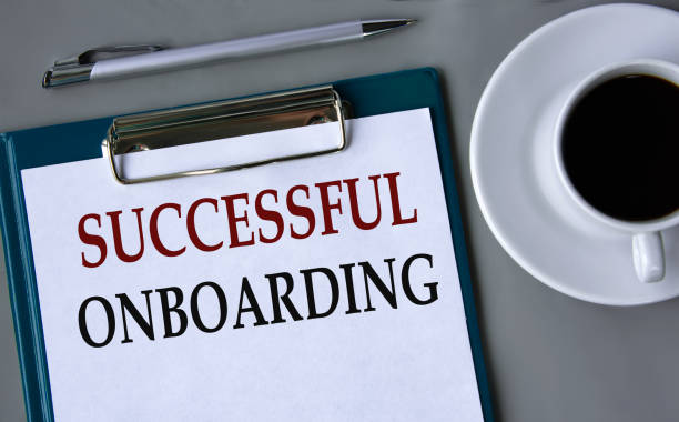 istock SUCCESSFUL ONBOARDING- words on a white sheet on a gray background with a pen and a cup of coffee 1960427029