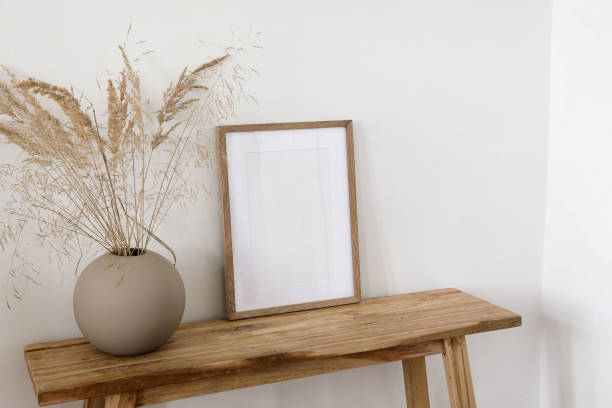 istock Modern interior. Beige ball vase with dray bunny tail, festuca grass. Blank vertical wooden frame picture mock up on old wooden table, bench. White wall background. Neutral Scandinavian home. 1960428646