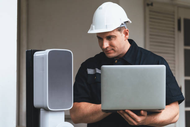istock Qualified technician working with laptop for home EV station. Synchronos 1960434527