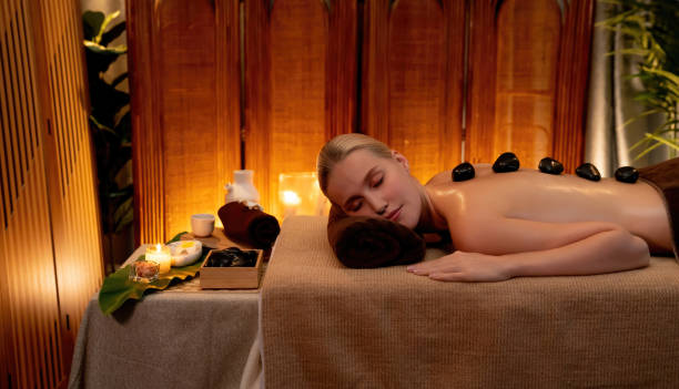 hot stone massage at spa salon in luxury resort with warm candle light.quiescent - lastone therapy massaging stone shiatsu - fotografias e filmes do acervo