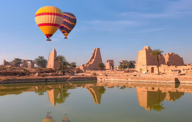 balon na ogrzane powietrze przelatujący nad starożytną świątynią w karnaku w luksorze - zrujnowane teby w egipcie - luxor africa archaeology architecture zdjęcia i obrazy z banku zdjęć