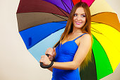 Woman in summer dress holds colorful umbrella