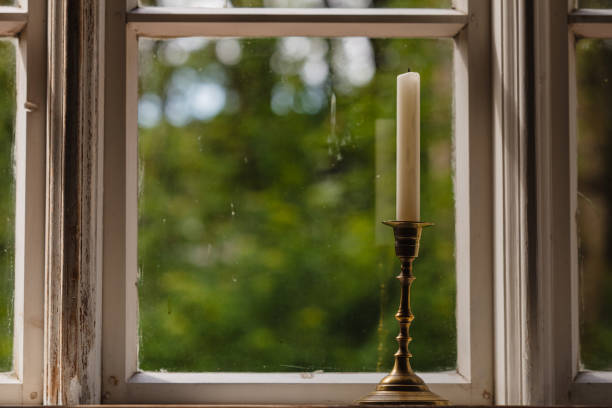 istock Old vintage window and vertical candle in candlestick 1960488104
