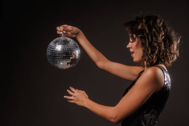 istock Cool young woman playing with a disco ball against the light 1960500308