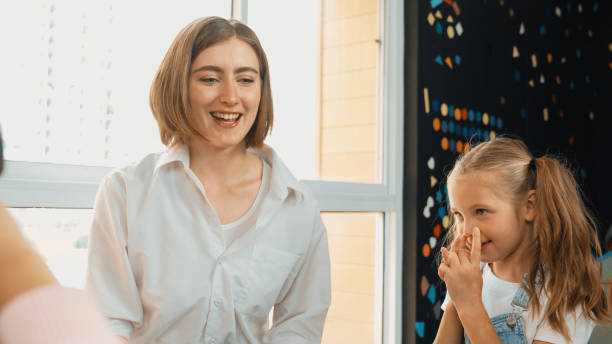 istock Beautiful teacher teach about body organ while student touch nose. Erudition. 1960523287