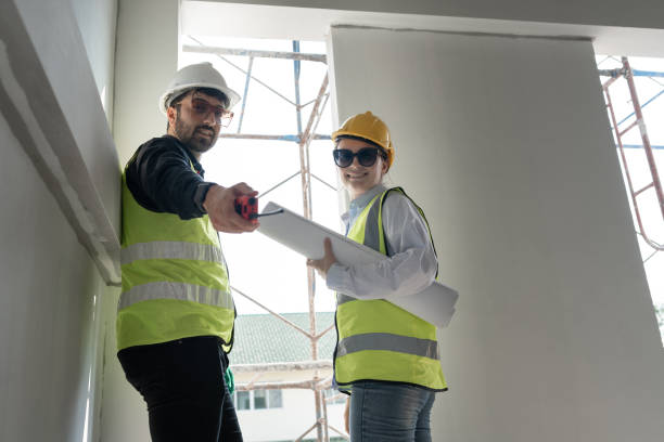 istock Caucasian engineer man and woman working with paper work at construction site 1960526468