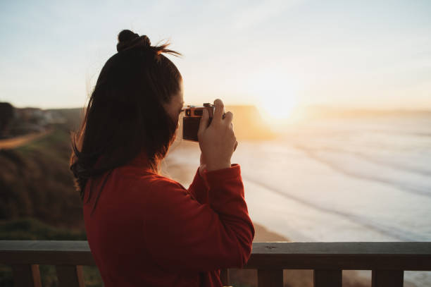 istock Woman with camera at sunset 1960560572