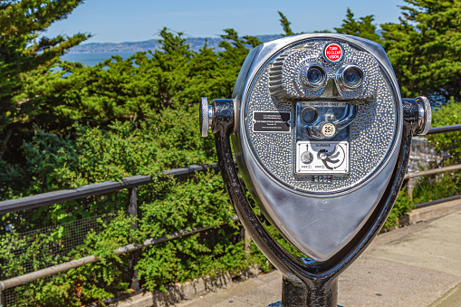 San Francisco, California, USA - 22 April, 2017: Coin operated binoculars overlooking Alcatraz Island, San Francisco City. Touristic binocular telescope look at the city with view mountains