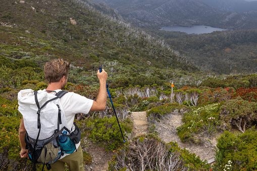 Embark on an adventure with a determined man traversing a long-distance trail. Against the backdrop of a dramatic stormy sky, his journey unfolds, encapsulating resilience and exploration in the face of nature's challenges.