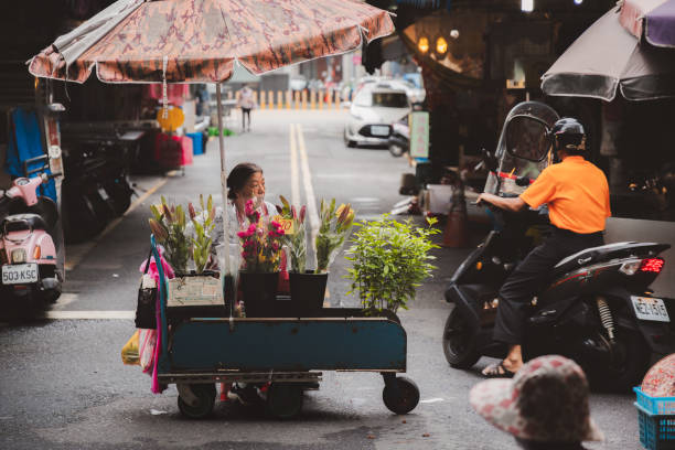 Yilan, Republic of China - October 2, 2023: Street vendors and shoppers at a colourful, bustling day market in the city of Yilan, Taiwan.